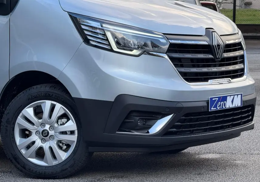 Vue intérieure côté conducteur du Renault Trafic cabine approfondie 2025, sièges gris et tableau de bord noir.