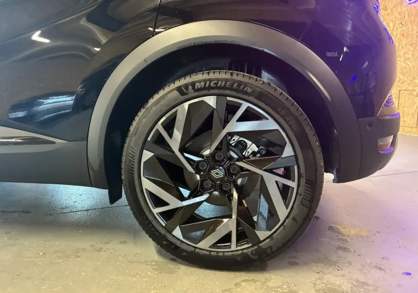 Gros plan sur la roue avant droite du Renault Captur noir étoile métal avec jante diamantée bicolore et pneu Michelin.