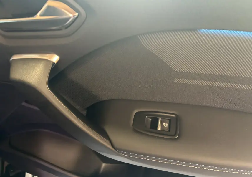Gros plan sur la poignée intérieure côté gauche du Renault Captur E-Tech noir étoile avec bouton de lève-vitre.