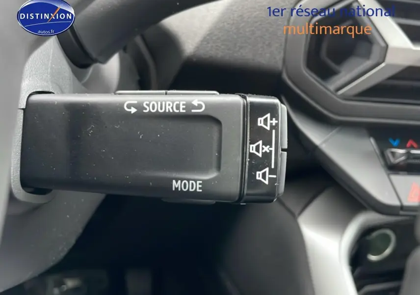 Gros plan sur la commande au volant du DACIA BIGSTER noir, avec tableau de bord et console partiellement visibles.