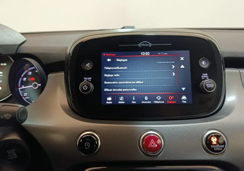 Vue rapprochée du tableau de bord de la Fiat 500X 2021, écran tactile central allumé avec menu réglages visible.