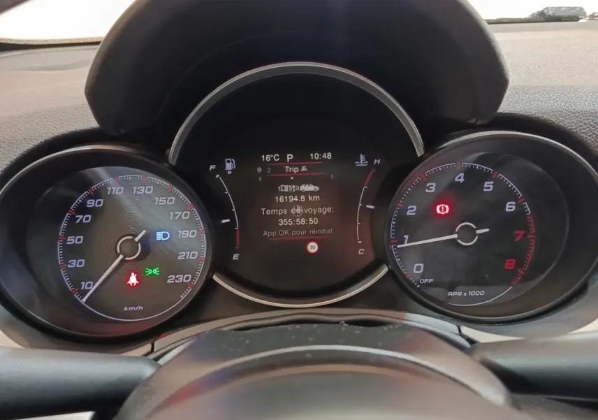 Vue rapprochée du tableau de bord de la Fiat 500X noir, affichant les compteurs et l'écran digital central.