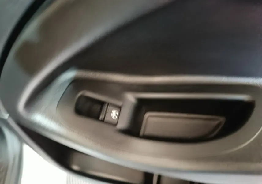 Gros plan sur la commande de lève-vitre côté gauche intérieur d'une FIAT 500X noire de 2021.