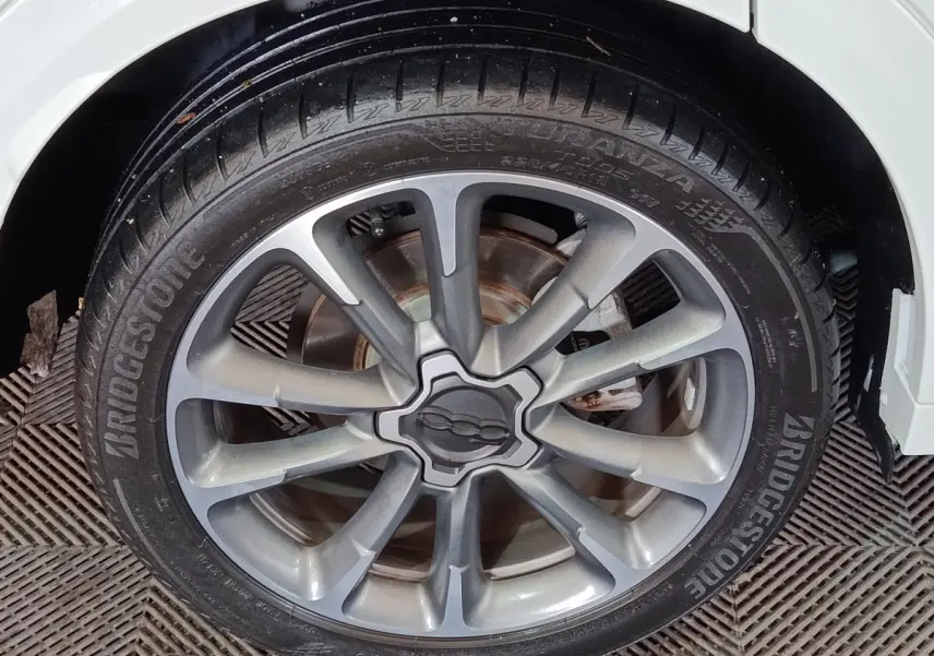 Gros plan sur la jante alliage grise et le pneu Bridgestone d'une FIAT 500X noire, vue côté droit arrière.