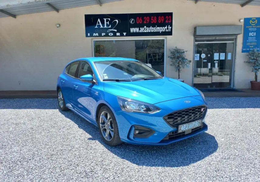 Ford Focus 2019 bleu en 3/4 avant droit, version ST-Line avec calandre noire et jantes alliage visibles.