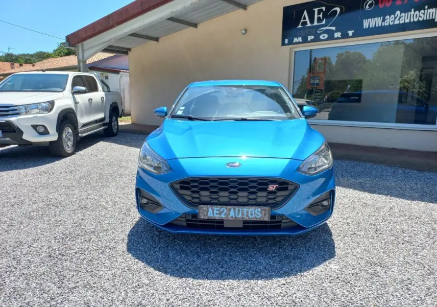 Vue de face d'une Ford Focus ST-Line bleu vif, avec calandre hexagonale et logo ST bien visible.