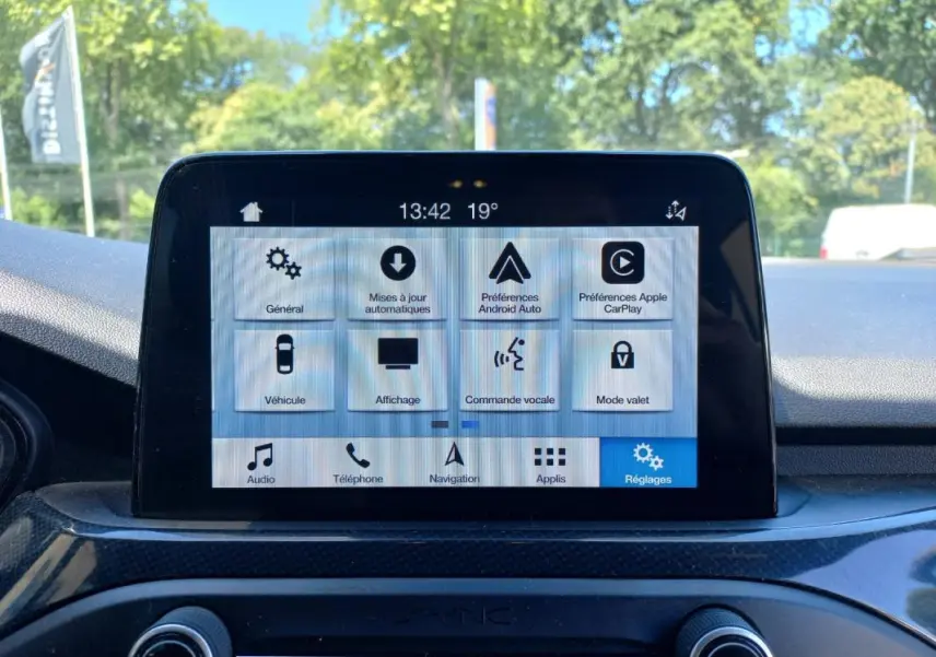 Écran tactile central de la Ford Focus 2019 bleu, vue frontale du système multimédia avec menu réglages affiché.