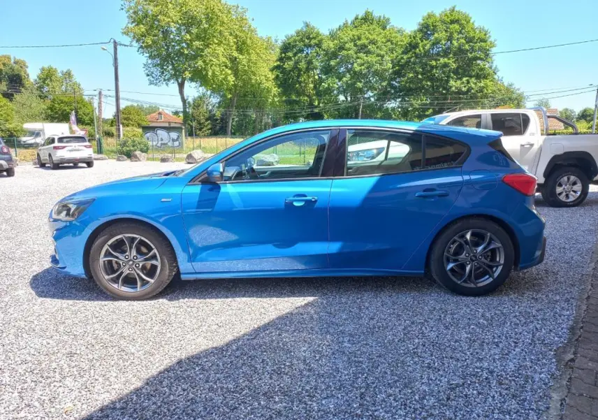Vue de profil côté gauche d'une Ford Focus 2019 bleue ST-LINE avec jantes alliage et carrosserie compacte.