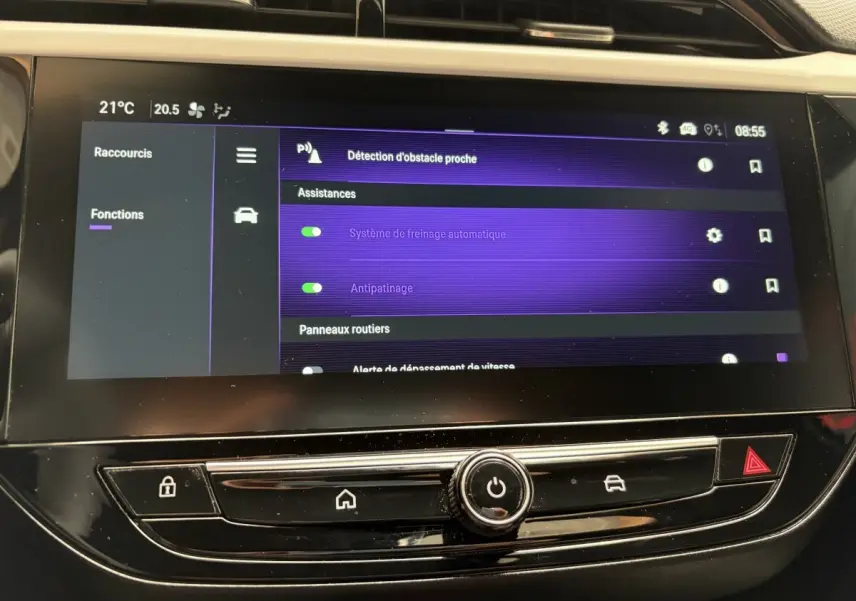 Vue rapprochée de l'écran tactile central de l'Opel Corsa 2025 gris clair affichant les assistances à la conduite activées.