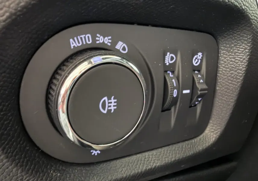 Gros plan sur la molette de réglage des phares et des feux antibrouillard dans l’habitacle de l’Opel Corsa gris clair 2025.