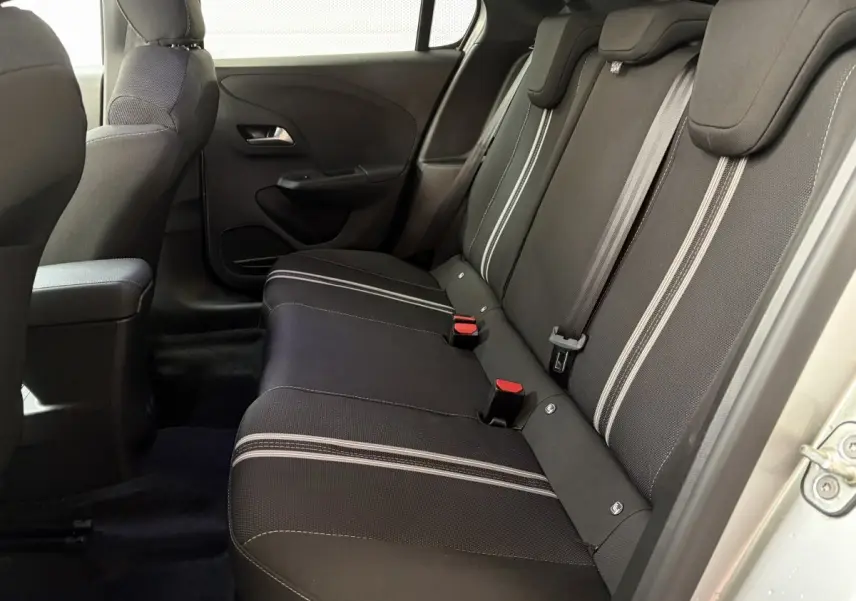 Vue intérieure côté droit montrant la banquette arrière noire avec surpiqûres claires de l'Opel Corsa 2025.