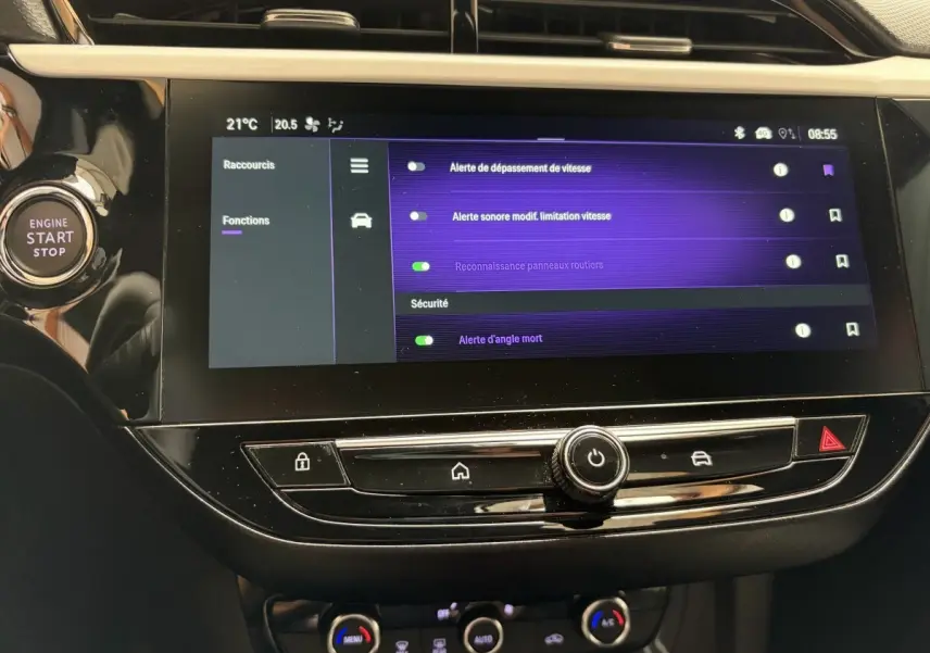 Vue rapprochée de l'écran tactile central noir de l'Opel Corsa 2025 avec menu de sécurité affiché et bouton start/stop à gauche.