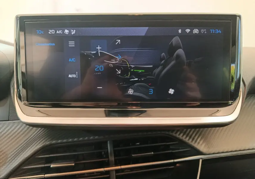 Écran tactile central affichant la climatisation dans l’habitacle d’une Peugeot 208 gris foncé, vue de face.