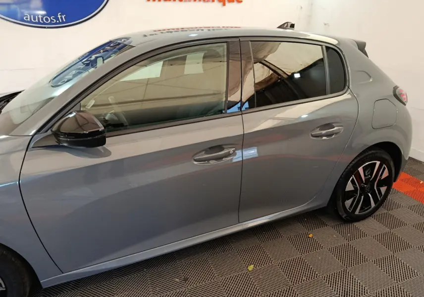 Vue latérale droite d'une Peugeot 208 PureTech 100 S&S Allure gris foncé avec rétroviseurs noirs et jantes stylisées.