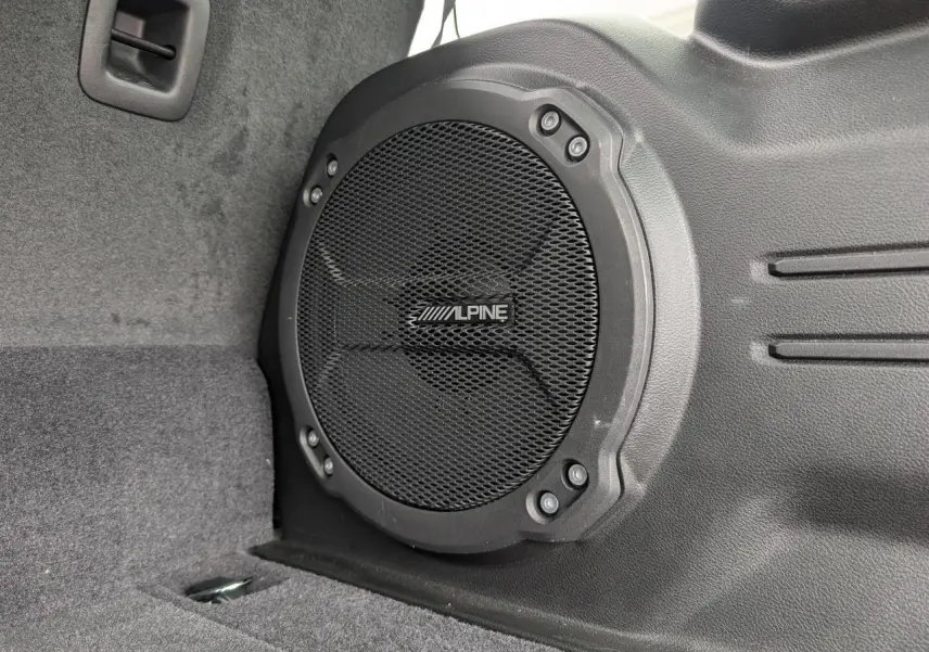 Gros plan sur le haut-parleur Alpine noir intégré dans le coffre du Jeep Wrangler 2024 Unlimited Sahara.