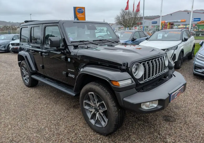 Jeep Wrangler 2024 noir en 3/4 avant droit avec jantes alliage 20 pouces et marchepieds visibles.