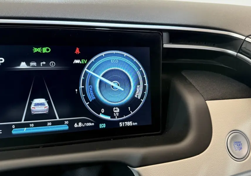 Gros plan sur l'écran digital du tableau de bord du Hyundai Tucson gris foncé avec bouton start/stop visible.