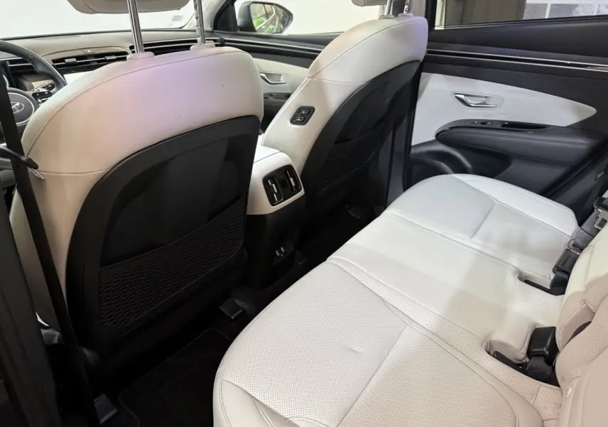 Vue intérieure arrière côté droit du Hyundai Tucson 1.6 Hybrid 230 Executive avec sièges cuir beige et finitions noires.