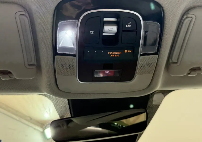 Vue intérieure du plafonnier du Hyundai Tucson gris foncé 2021 avec commandes d’éclairage et indicateur airbag passager.