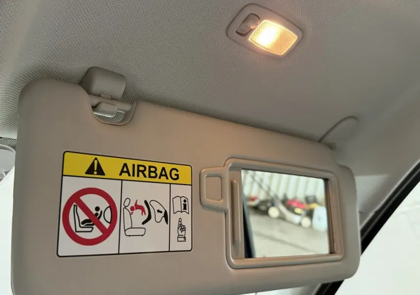 Détail du pare-soleil côté conducteur avec miroir et avertissement airbag dans l’habitacle gris clair du Hyundai Tucson 2021.