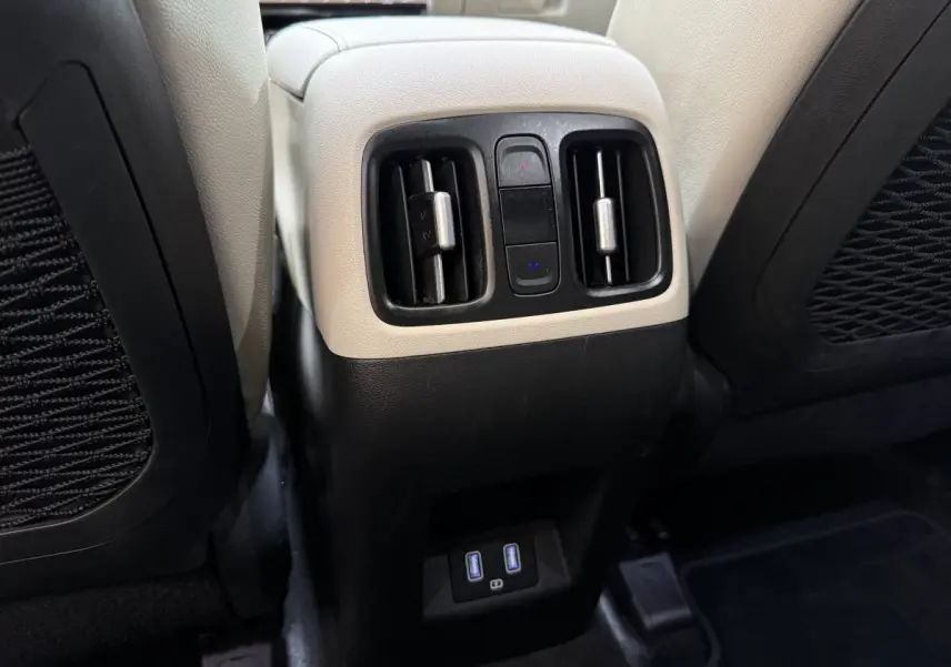 Détail des aérateurs arrière et ports USB sur la console centrale beige et noire du Hyundai Tucson 1.6 Hybrid 230 Executive.