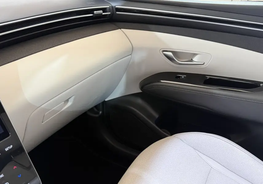 Vue intérieure côté passager avant du Hyundai Tucson 1.6 Hybrid 230 Executive, avec sellerie claire et garnitures bicolores.