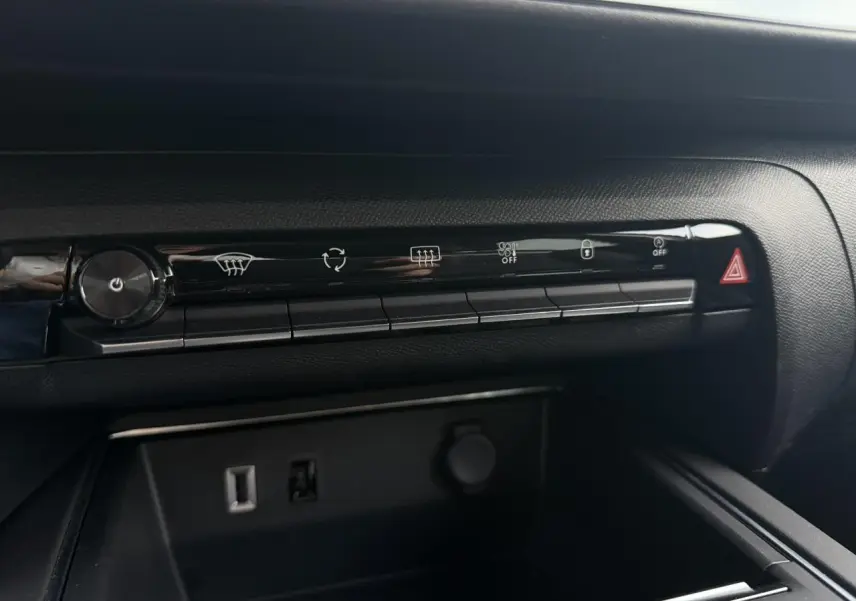 Gros plan sur la console centrale noire du Citroën C5 Aircross 2025 avec commandes climatisation et prises USB visibles.