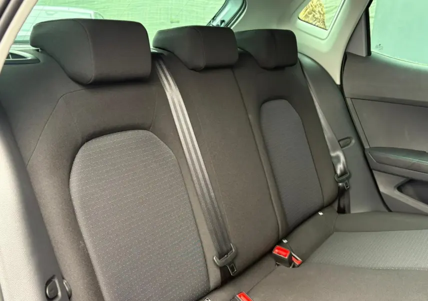 Vue intérieure du siège arrière droit de la SEAT IBIZA 2024, tissu noir avec ceinture de sécurité visible.