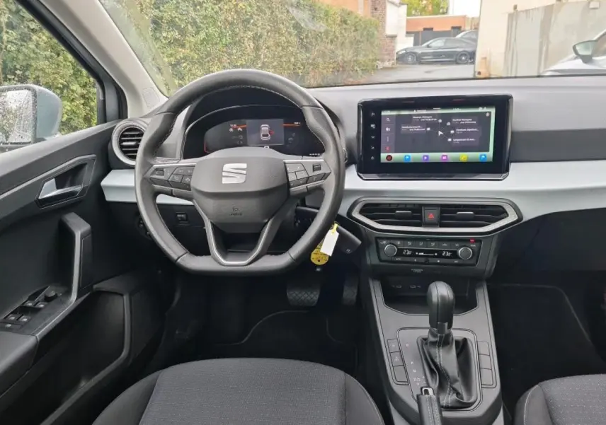 Vue intérieure frontale du poste de conduite de la SEAT Ibiza 2024 avec volant cuir multifonction et écran tactile GPS.