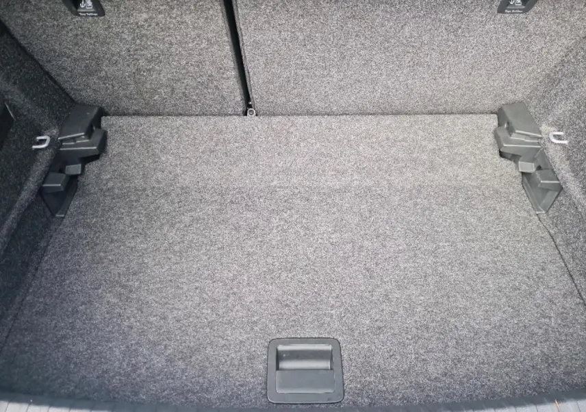 Coffre spacieux et propre de la SEAT IBIZA 2024, vue intérieure sans chargement, revêtement gris uniforme.