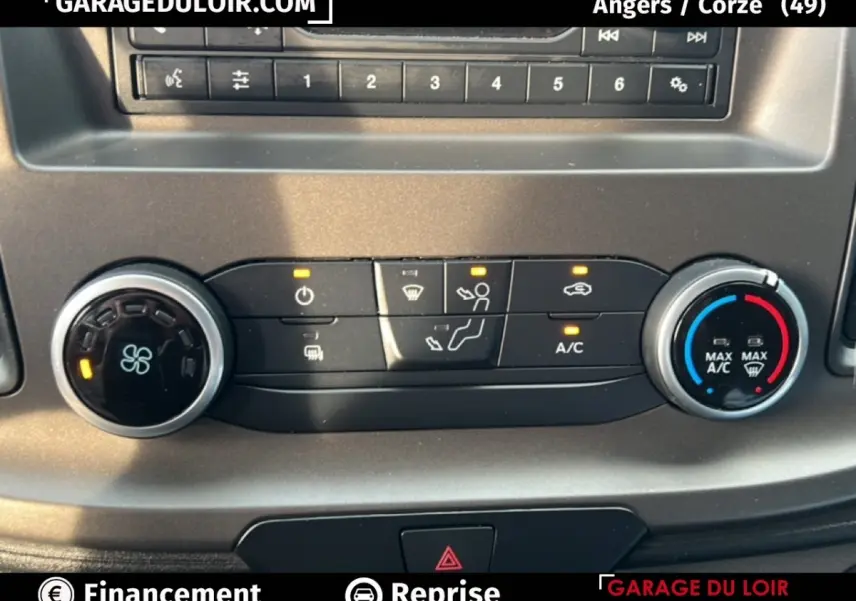 Gros plan sur la commande de climatisation du Ford Transit Custom blanc, avec boutons et voyants allumés.