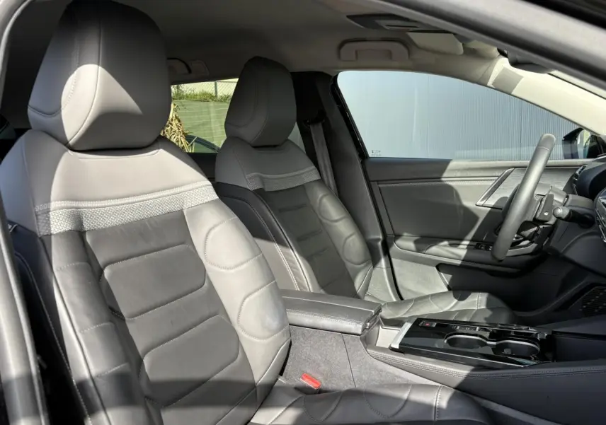 Vue intérieure côté gauche montrant les sièges avant en cuir noir et la console centrale du Citroën C5 X 2024.