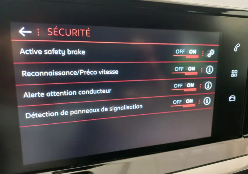 Écran tactile intérieur du Peugeot 208 blanc, affichant les options de sécurité activées.