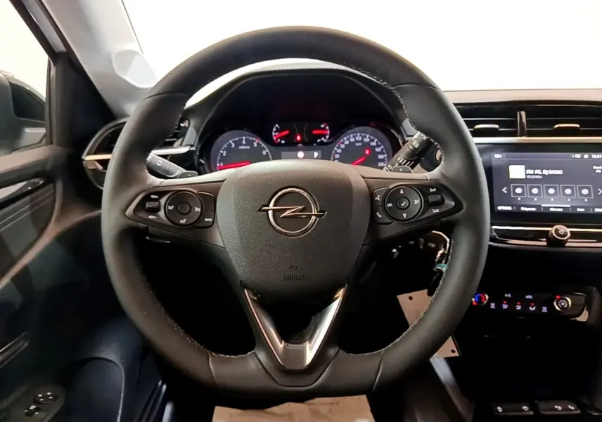 Vue intérieure centrée sur le volant cuir multifonctions et l'écran tactile 7 pouces de l'Opel Corsa 2023 blanc.