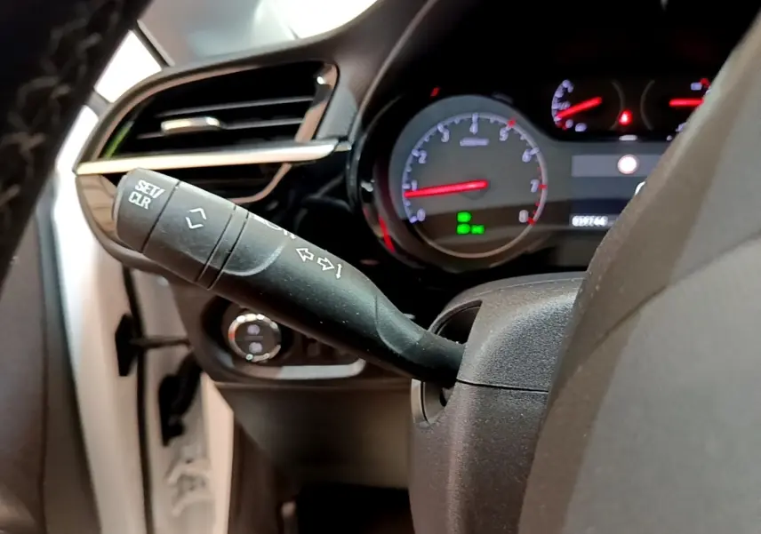 Gros plan sur la commande de clignotant et le tableau de bord éclairé d’une Opel Corsa blanche de 2023.