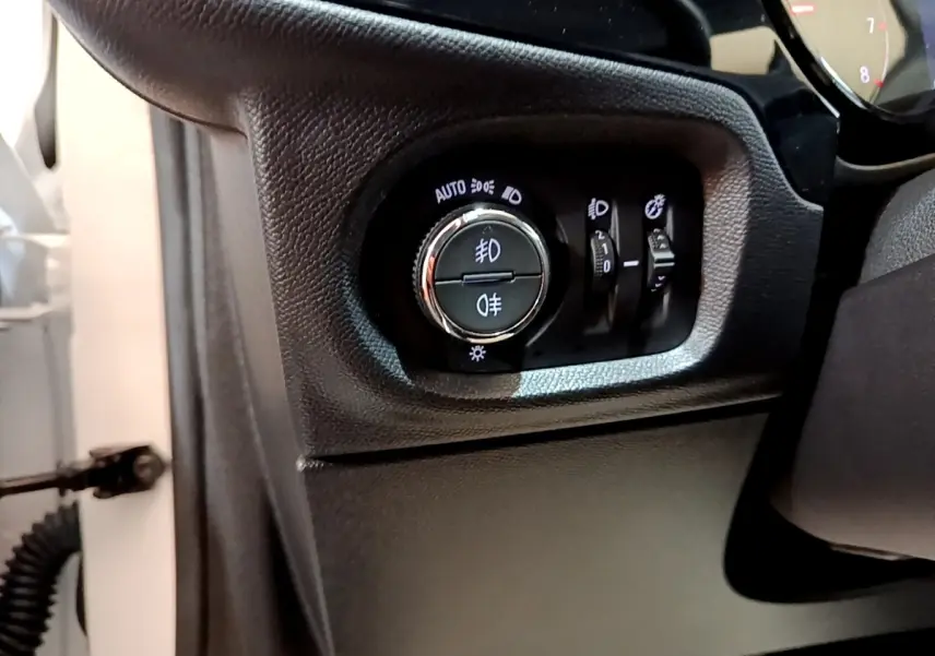 Gros plan sur le panneau de commande des phares à gauche du volant d'une Opel Corsa blanche 2023.