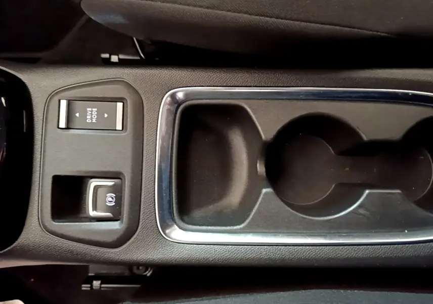 Vue rapprochée de la console centrale noire de l’Opel Corsa 2023 avec commandes Drive Mode et frein à main électrique.