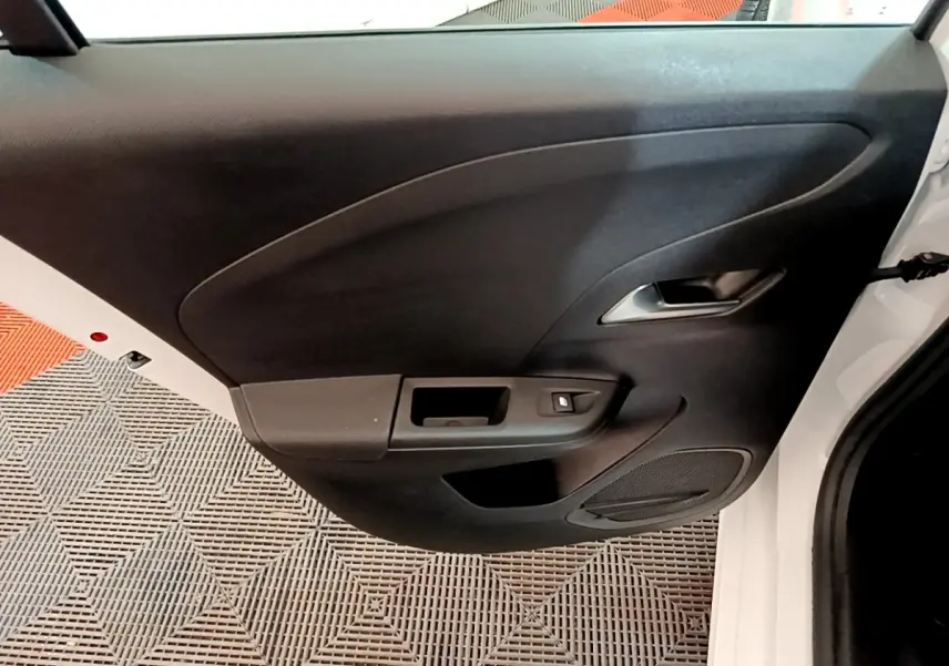 Vue rapprochée de la porte arrière droite noire avec poignée argentée d’une Opel Corsa blanche 2023.