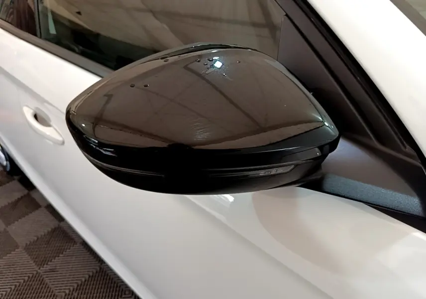 Gros plan sur le rétroviseur extérieur noir côté gauche d'une Opel Corsa blanche 2023 vue de profil.