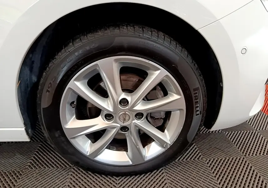 Gros plan sur la roue avant droite d’une Opel Corsa blanche avec jante alliage et pneu Pirelli.
