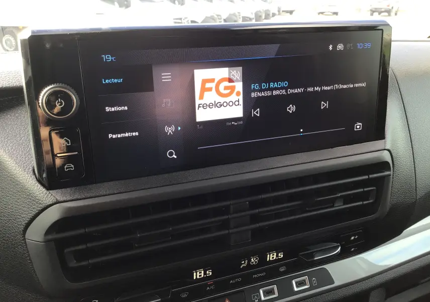 Vue rapprochée de l'écran tactile central du Peugeot Expert XL noir, affichant la radio FG DJ avec commandes tactiles.