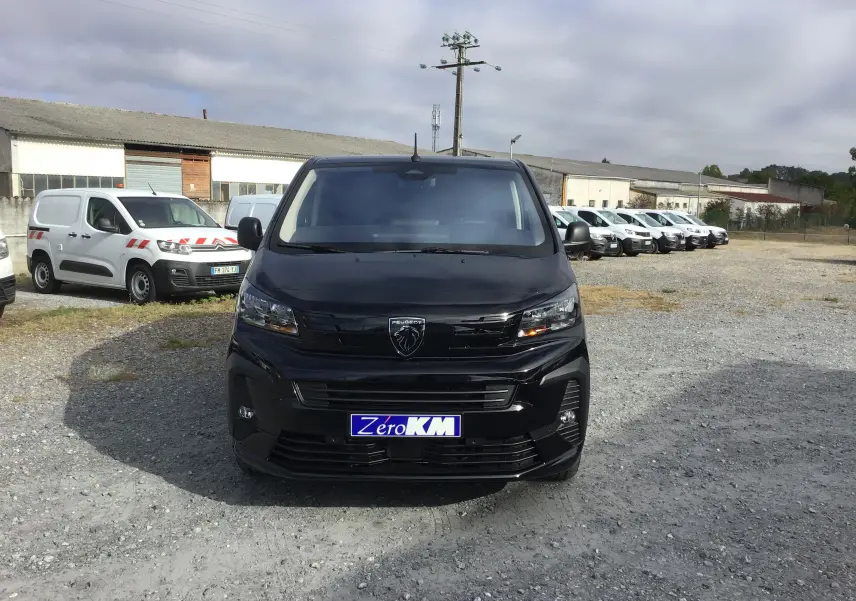 Vue avant d’un Peugeot Expert Cabine Approfondie noir, avec calandre et logo Peugeot bien visibles, sur un parking extérieur.