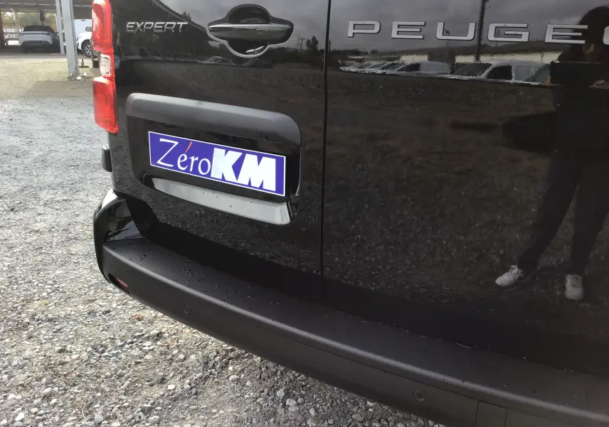 Gros plan sur l'arrière noir du Peugeot Expert Cabine Approfondie avec logo et plaque d'immatriculation "Zero KM".