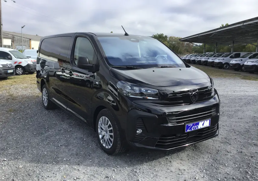 Peugeot Expert Cabine Approfondie noir vu en 3/4 avant droit sur parking avec plusieurs véhicules blancs en arrière-plan.