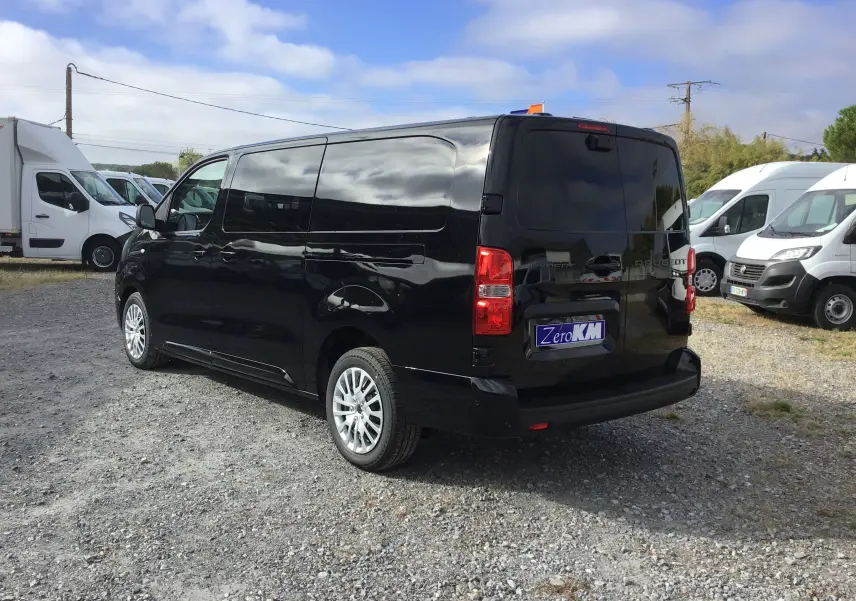 Vue 3/4 arrière droite d’un Peugeot Expert Cabine Approfondie noir, avec jantes argentées et vitres teintées.