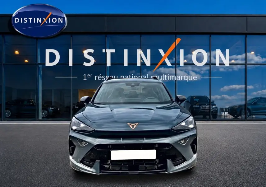 Vue frontale d'un CUPRA Formentor 1.5 etsi hybrid bleu fjord avec logo distinctif cuivré sur calandre noire.