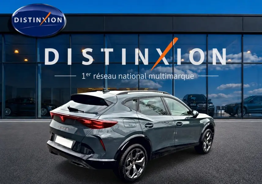 Vue 3/4 arrière droite d'un CUPRA Formentor bleu fjord avec jantes 18 pouces devant une vitrine Distinxion.