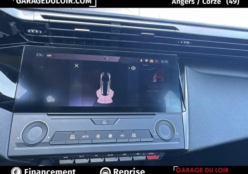 Vue rapprochée de l'écran tactile central et des commandes de climatisation du tableau de bord d'une Peugeot 308 gris clair 2023.