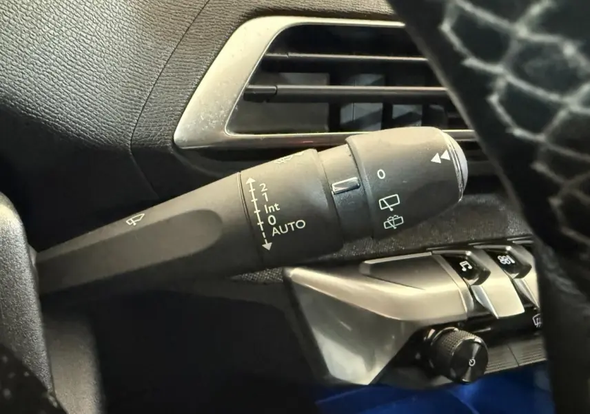 Gros plan sur la manette d’essuie-glace côté gauche du tableau de bord noir du Peugeot 3008 vert Puretech 2020.