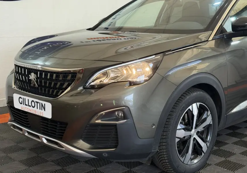 Vue 3/4 avant droit d’un Peugeot 3008 vert avec calandre noire et phares allumés dans un showroom.